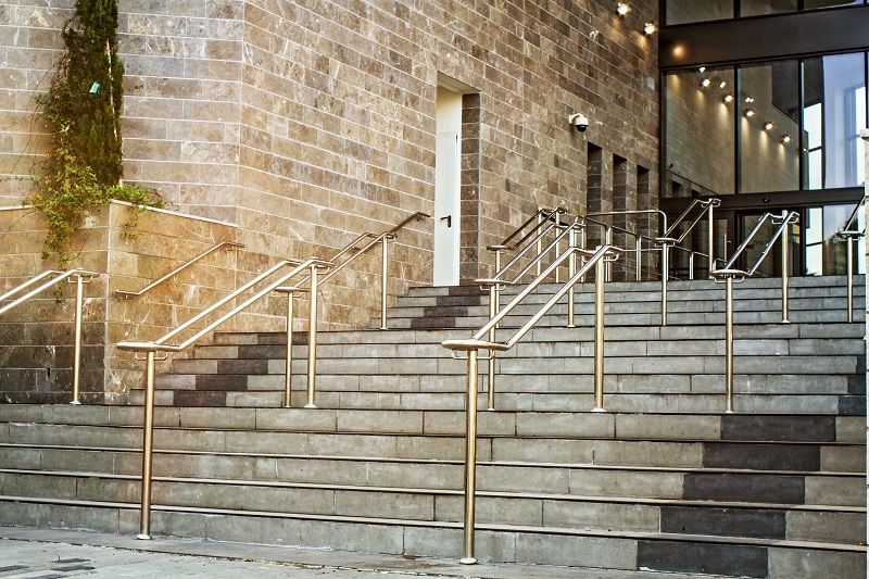Stainless steel handrails on wide external steps