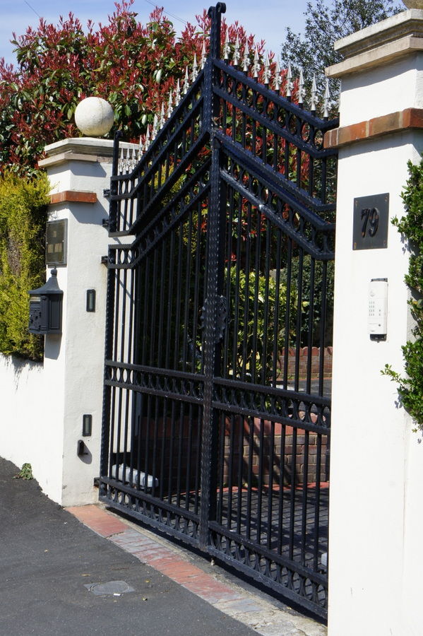 Ornate metal gates with an entry keypad on the pier
