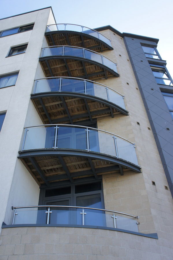 Curved glass balconies on several floors of an apartment building