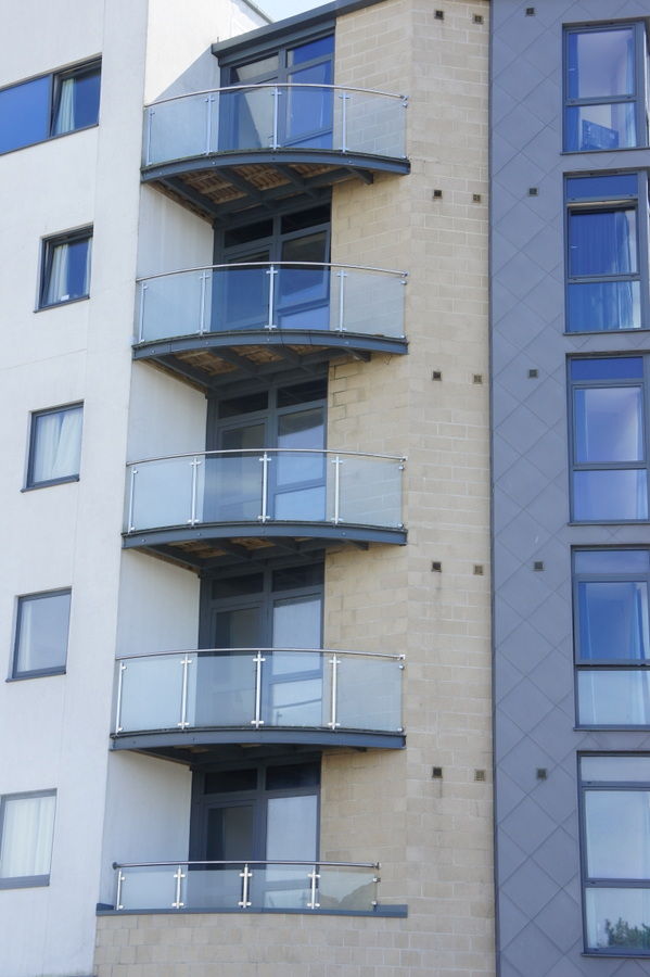 Stack of curved glass balconies on an apartment block