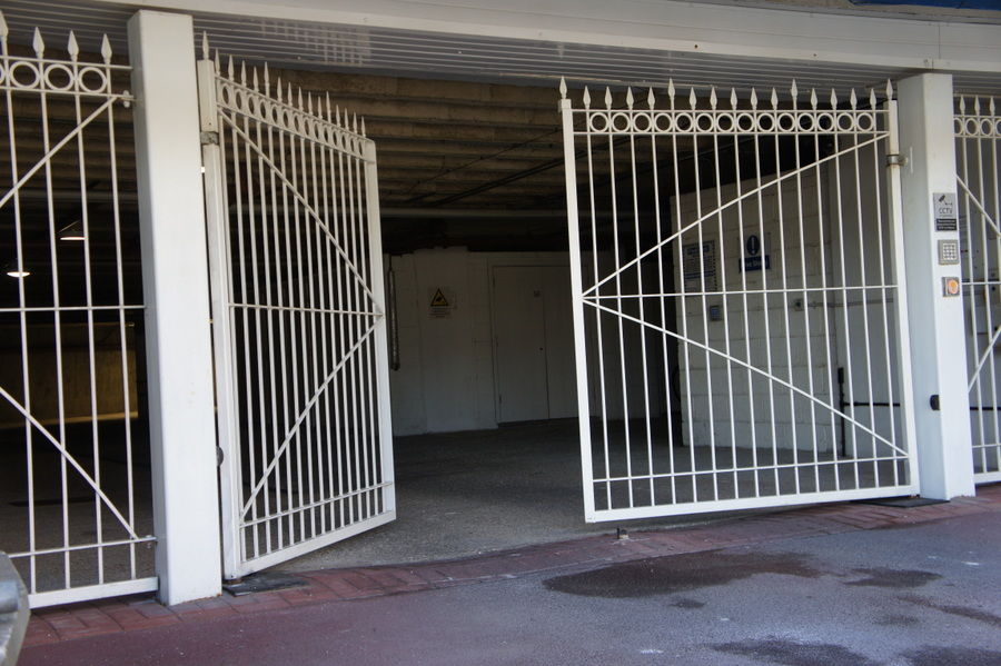 White metal car park gates swung open to show the entrance beyond