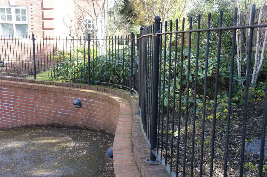 Black metal railings on a curved stepped brick wall