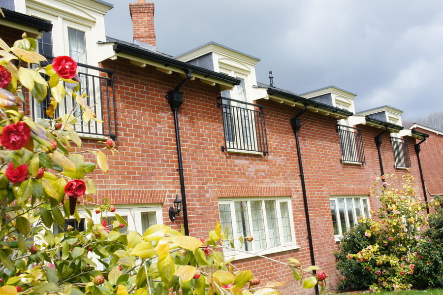 Row of black Juliet balconies on a brick terrace