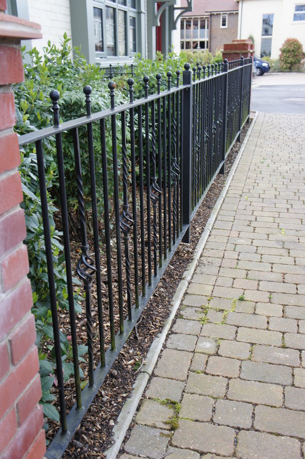 Black metal railings along a front garden path