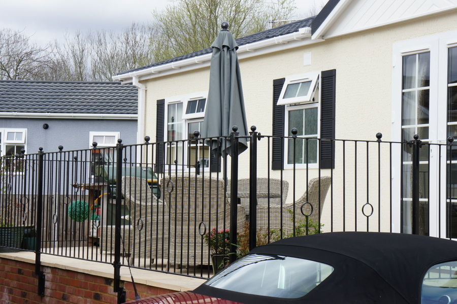 Park home balcony with black railings and ball-top posts