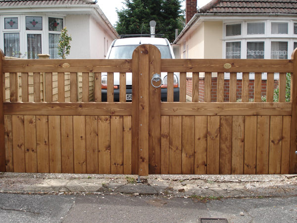 Timber driveway gates with open spindles along the top